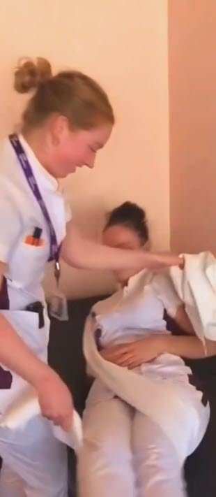Cuidadora usando lençol para ajudar idoso a levantar da cama com segurança