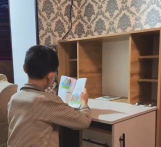 criança estudando em armário com mesa retrátil de madeira aberta