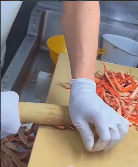 rolo de massa sendo usado sobre pata de caranguejo cozida para retirar a carne com facilidade